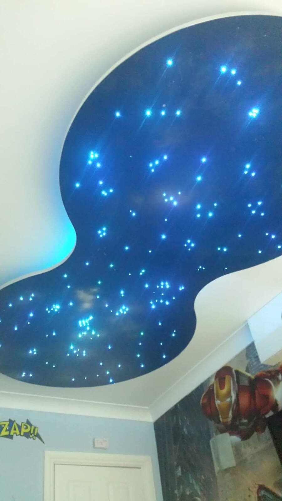 Fibre-optic star ceiling set into a curved recess in a child's bedroom, lit blue
